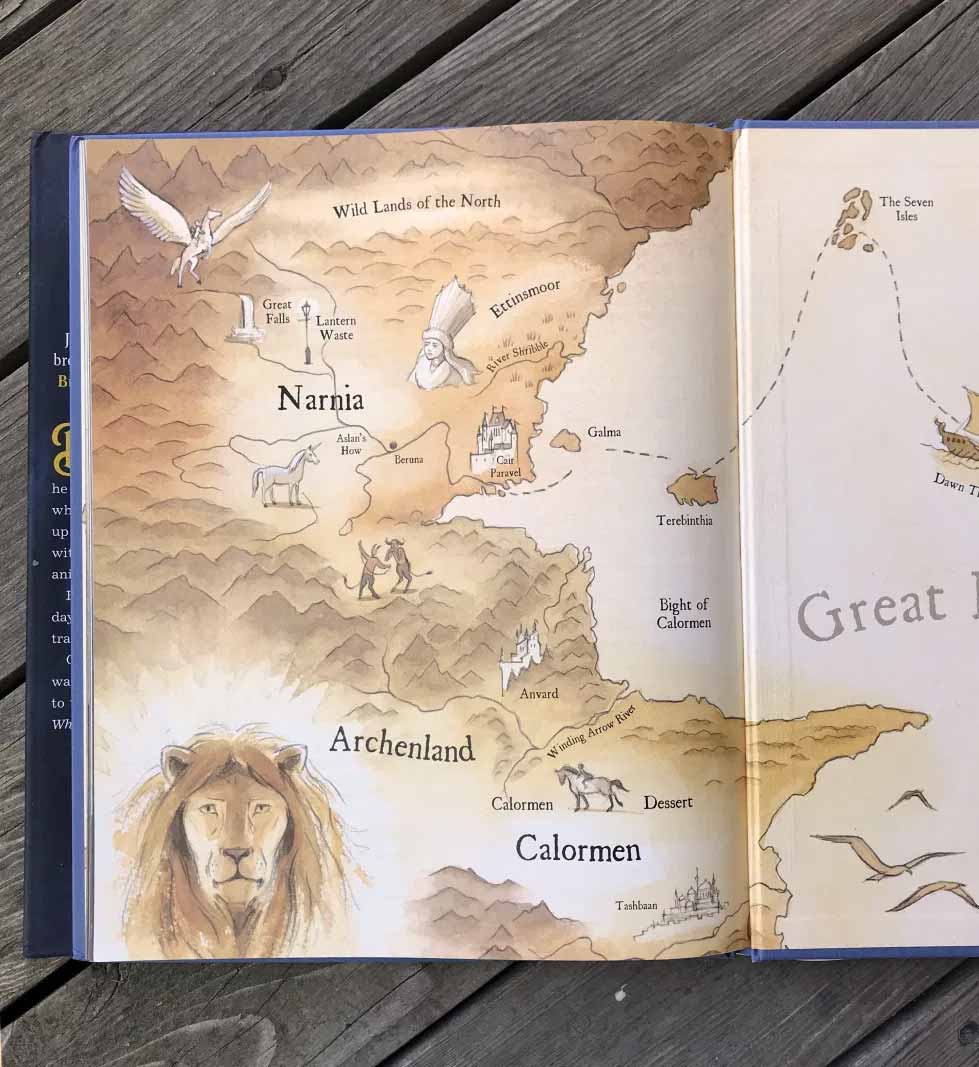 Photograph detail of watercolor map illustration from the interior of 'Finding Narnia' showing the lands of Narnia and a detail of the lion, Aslan's face.
